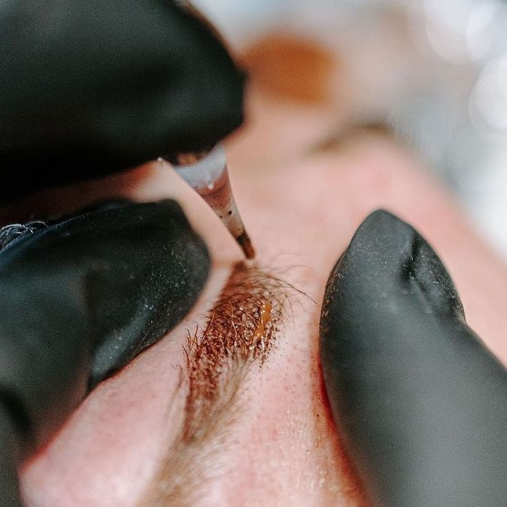 Close-up van wenkbrauwen die gepigmenteerd worden met gehandschoende handen